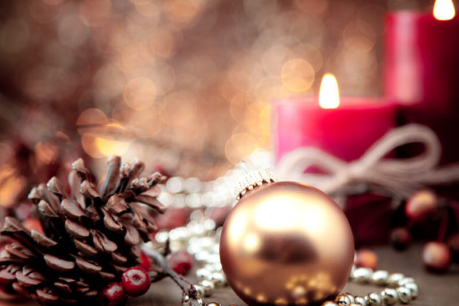 Foto von Weihnachtskugel vor Kerzen, ein beliebtes Dekorationsobjekt auch bei der Last Minute Weihnachtsfeier