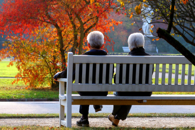 Das Foto zeigt ein Rentnerpaar, das auf einer Parkbank sitzt. Wer in den wohlverdienten Ruhestand geht, bekommt zum Teil deutlich weniger Betriebsrente als erwartet. Der betrieblichen Altersvorsorge setzen die niedrigen Zinsen zu. Firmen haften, wenn Versicherer und Pensionskassen garantierte Renten nicht erwirtschaften. Höchste Zeit, dass Unternehmen das eigene Vorsorgekonzept überprüfen.
