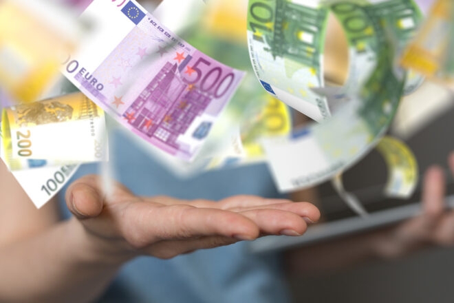 Foto zeigt eine Hand, auf die die Euro-Geldscheine regnen, die Unternehmen mit der Ist-Versteuerung anstatt der Soll-Versteuerung sparen können