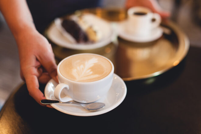 Foto von einer Bedienung, die Cappuccino serviert, steht als Symbol für den Minijob auf Abruf