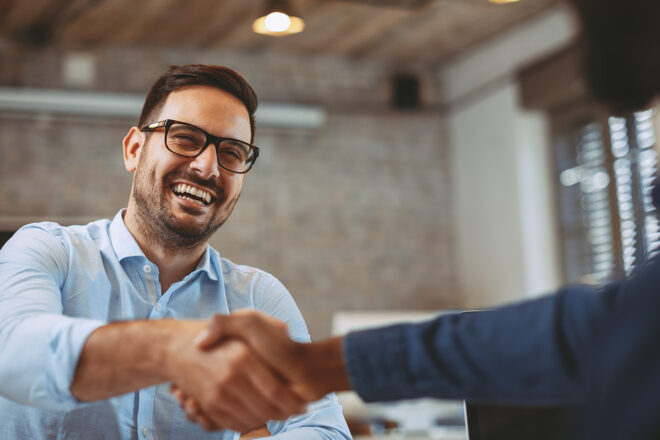 Foto zeigt Unternehmer beim Handschlag mit einem Kunden nach erfolgreicher Neukundengewinnung